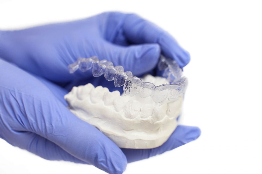 technician holding an Invisalign at Medford