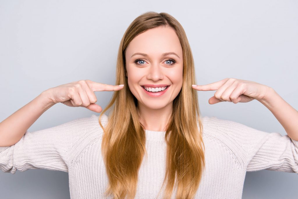 woman flashing a smile after visiting a dentist office in Medford