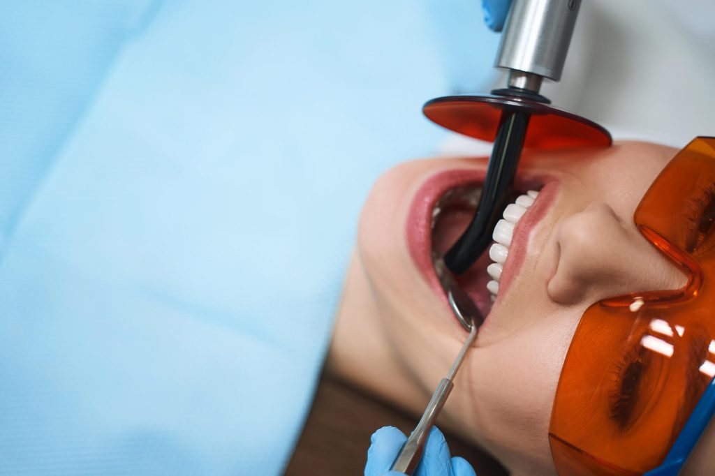 a root canal specialist in phillips working on a woman's decayed tooth