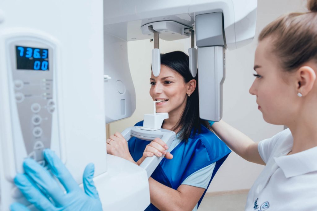 woman sits cone beam CT scan technology in Park Falls